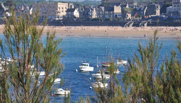 Vue sur la plage de Saint-Lunaire avec des bateaux amarrés au premier plan